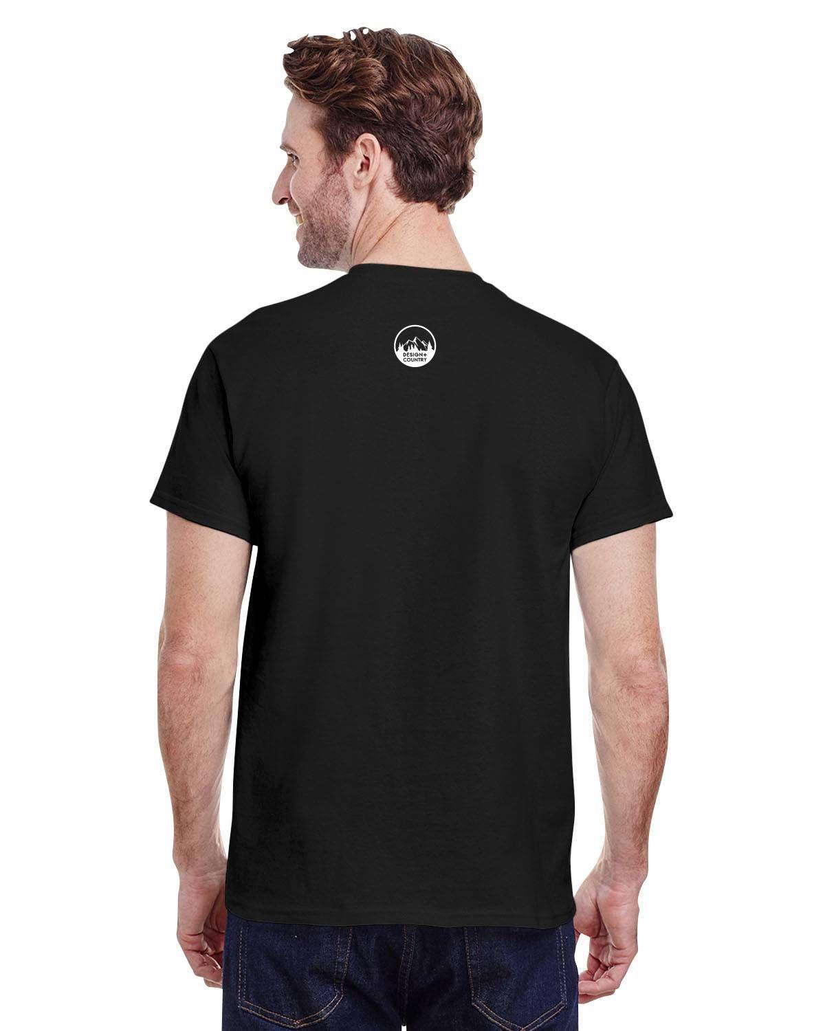 Man wearing black UFO Cowboy Abduction Unisex Tee, rear view, showcasing seamless neck and classic fit design.