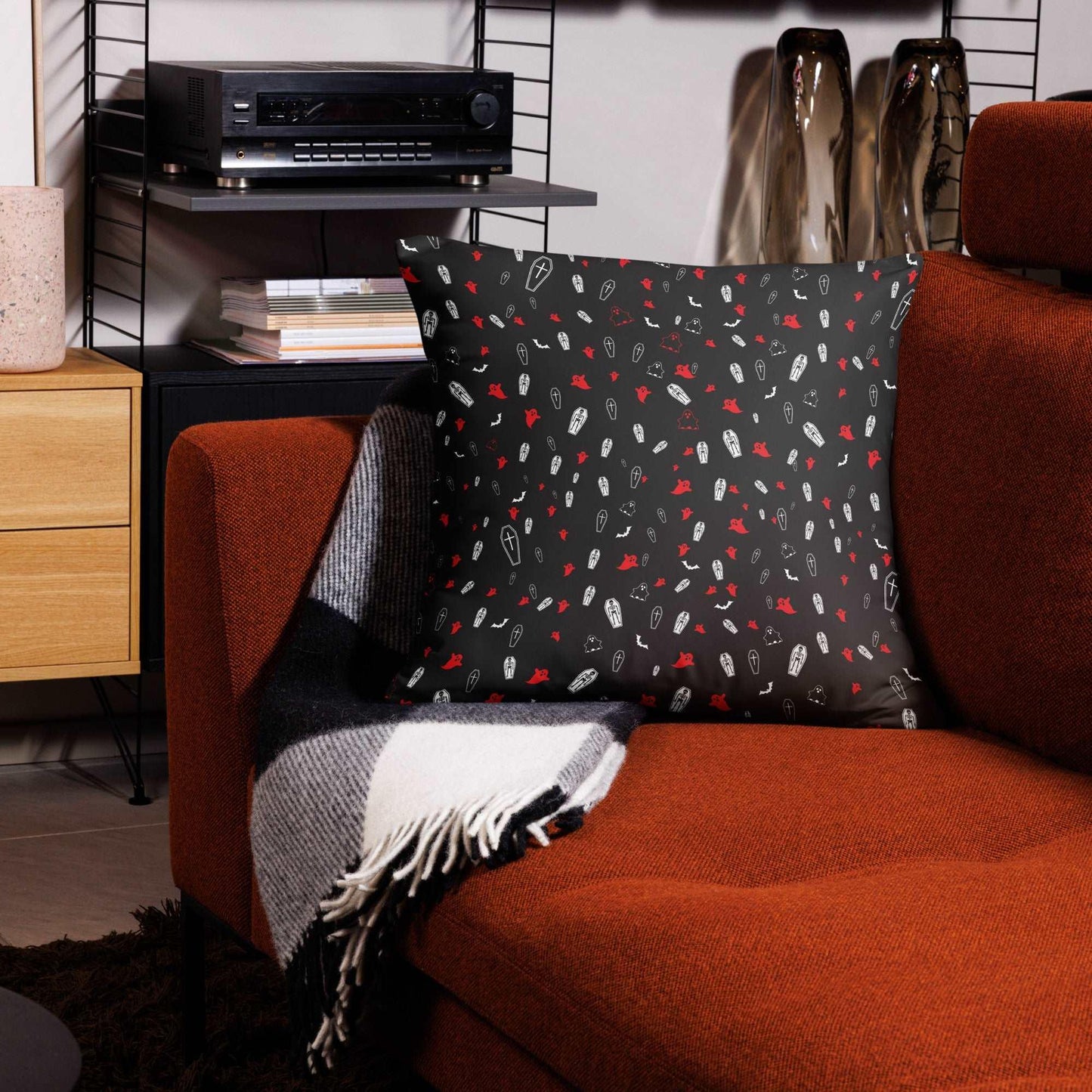 Spooky Accent Pillow with Halloween-themed ghosts, coffins, skeletons, and bats on a cozy sofa setup.