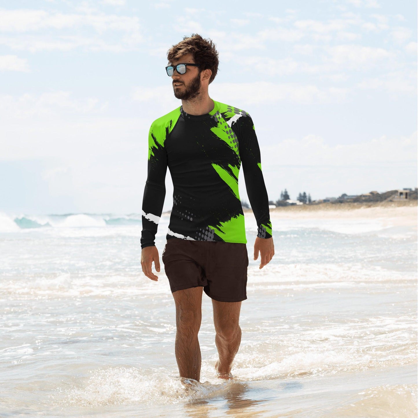 Green Burst Men's Rash Guard on beach, sleek green and black design, perfect for water sports.