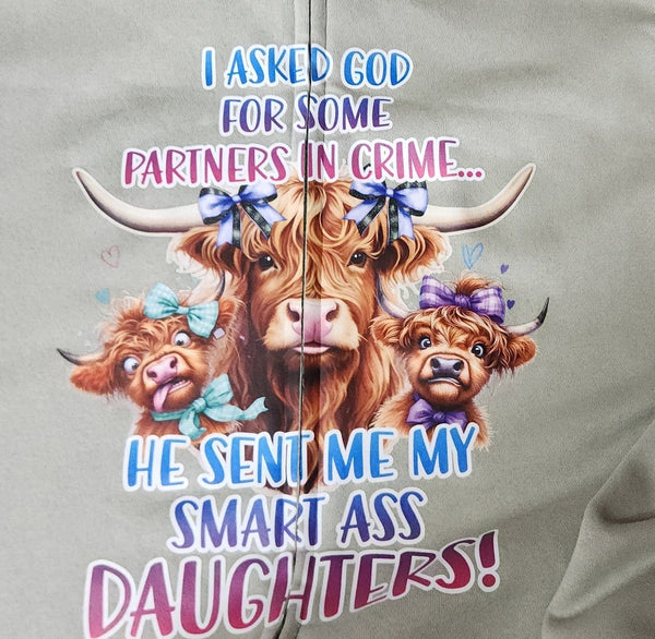 Gray sweatshirt with cartoon Highland cows and humorous text on a light gray background.