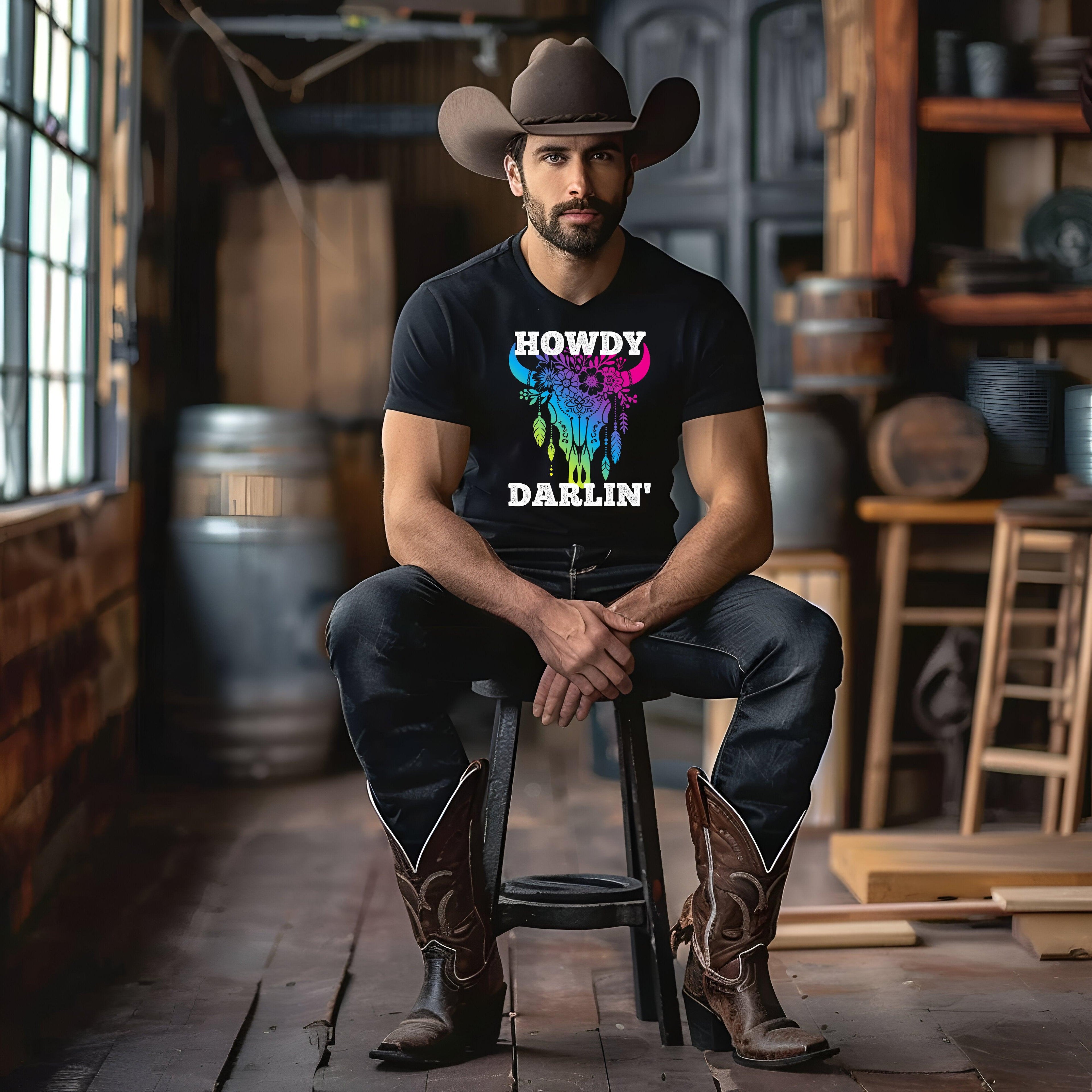 Cowboy wearing Howdy Darlin' Cowboy Tee, vibrant design, in rustic setting.