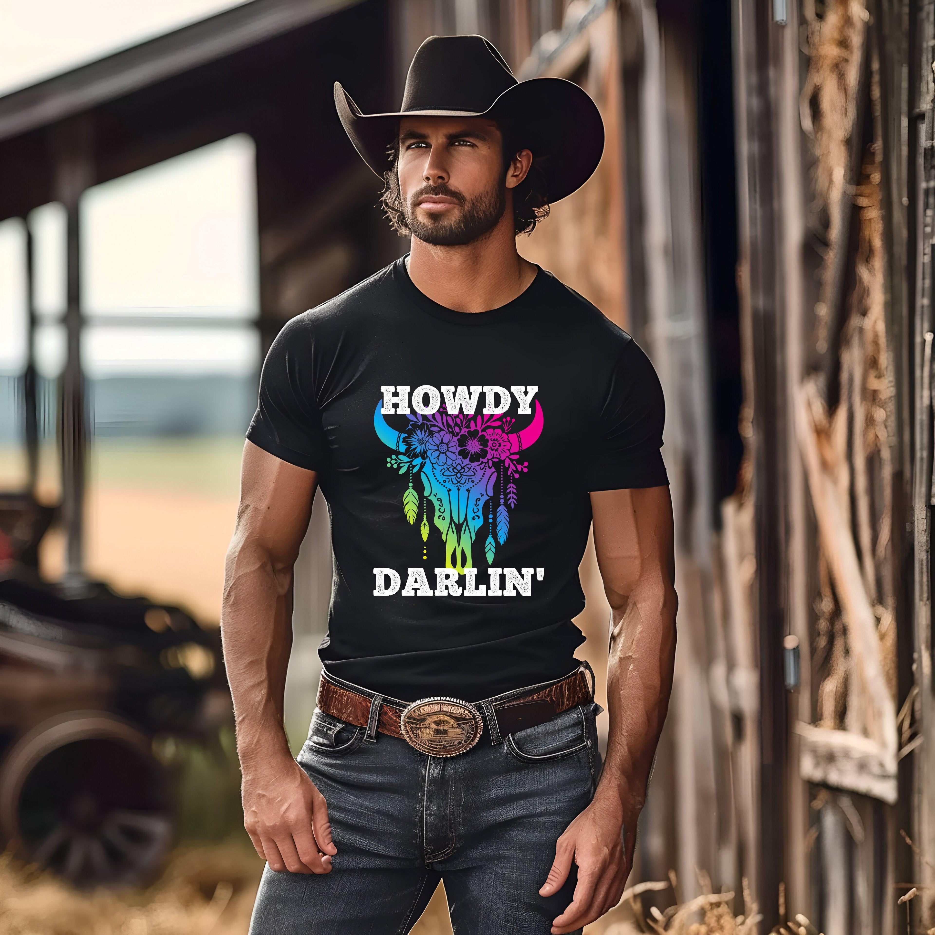 Howdy Darlin' Cowboy Tee with colorful bull skull design in a rustic setting.