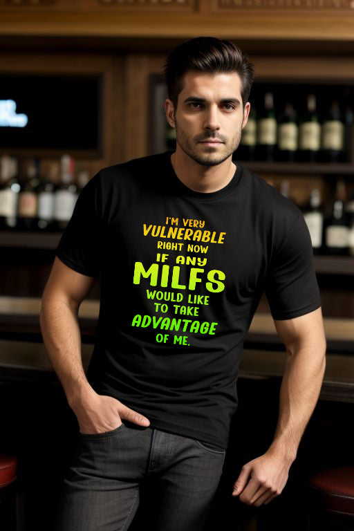 Black "Searching for a MILF" Tee with colorful text, worn by a person in a bar setting.