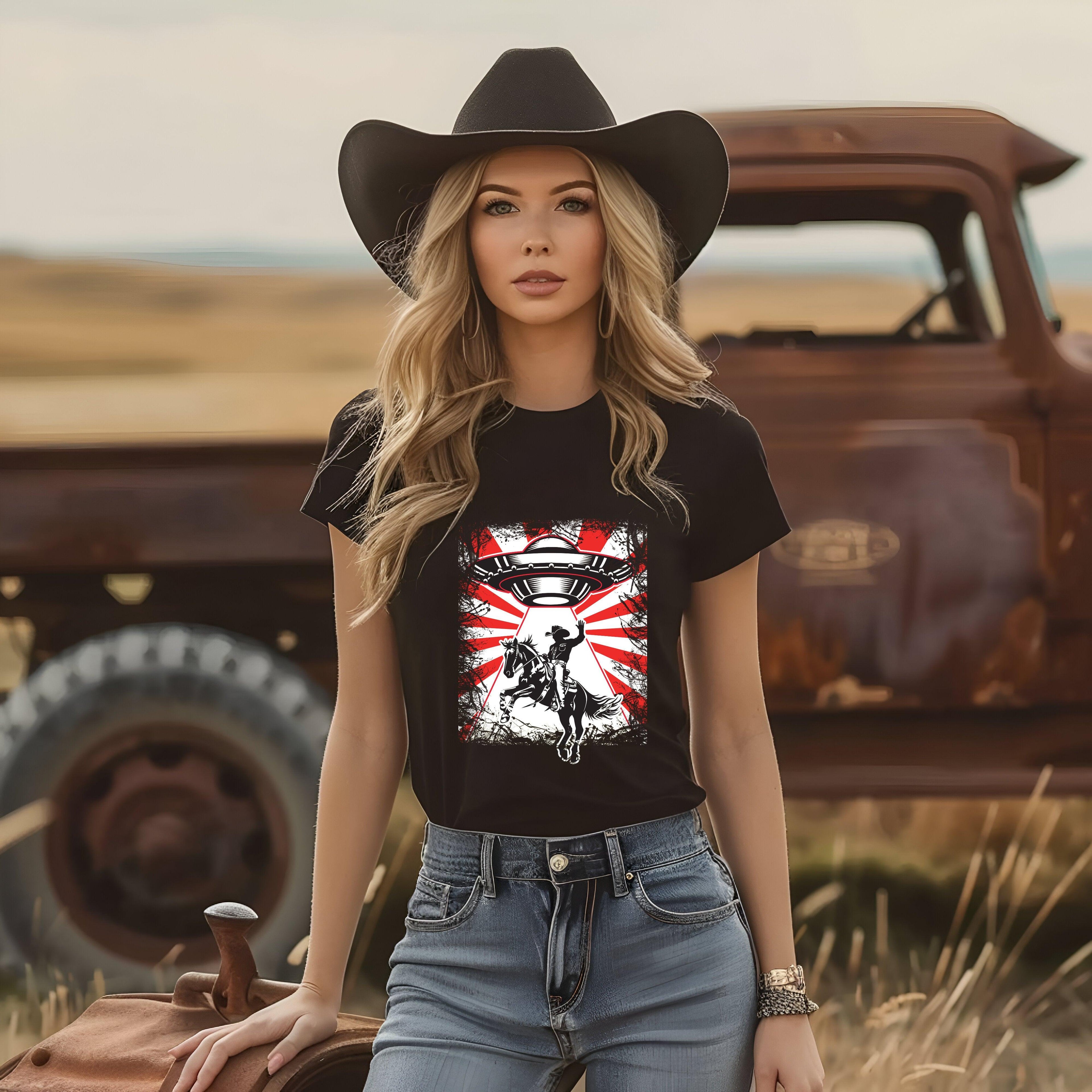 UFO Cowboy Abduction Unisex Tee with graphic design, worn by person in cowboy setting.