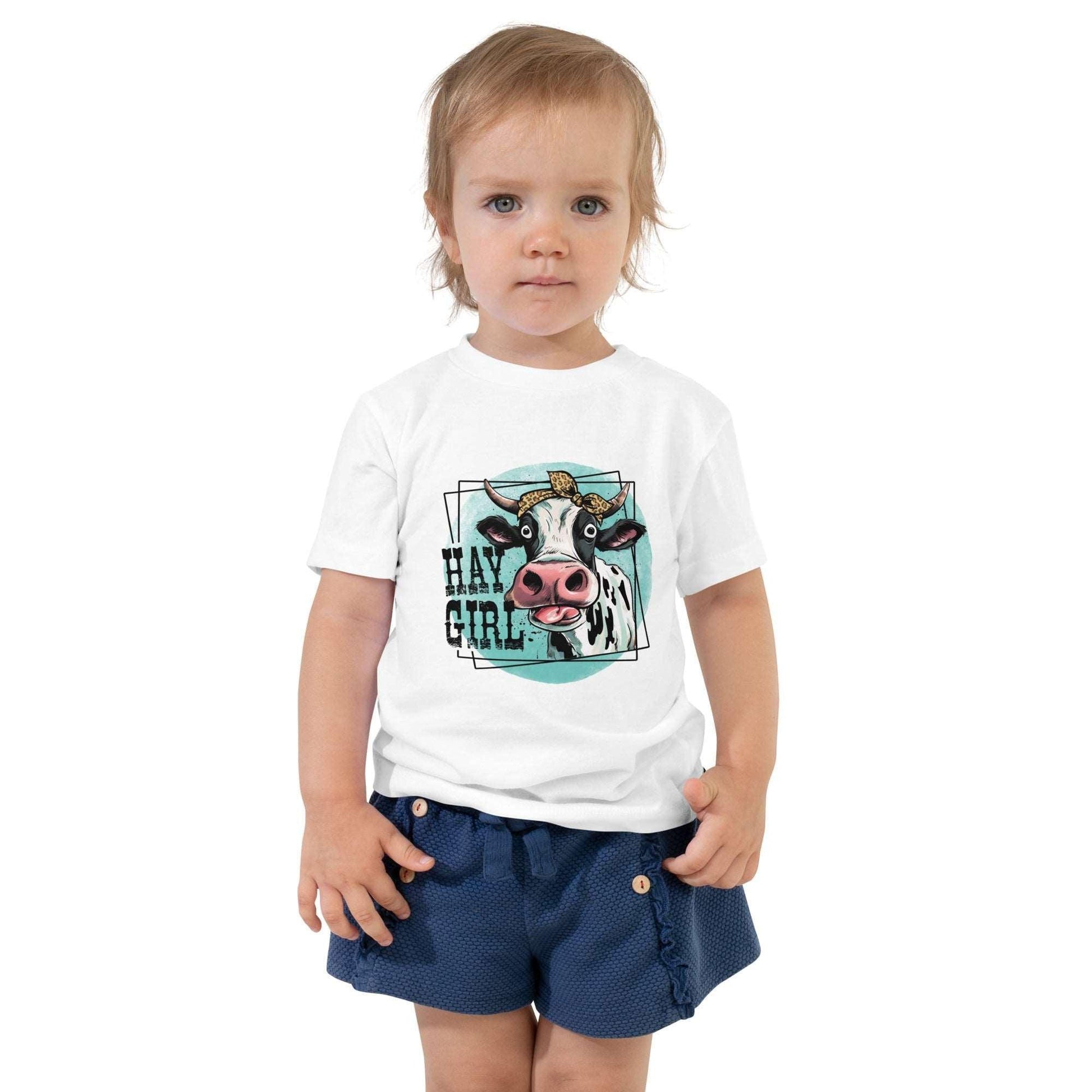 Hay Girl Toddler T-ShirtLet your toddler do their thing while feeling super comfy and looking extra stylish in this short-sleeve jersey t-shirt from 100% cotton in our Hay Girl! Perfect forT-ShirtDesign + CountryDesign + CountryHay Girl Toddler